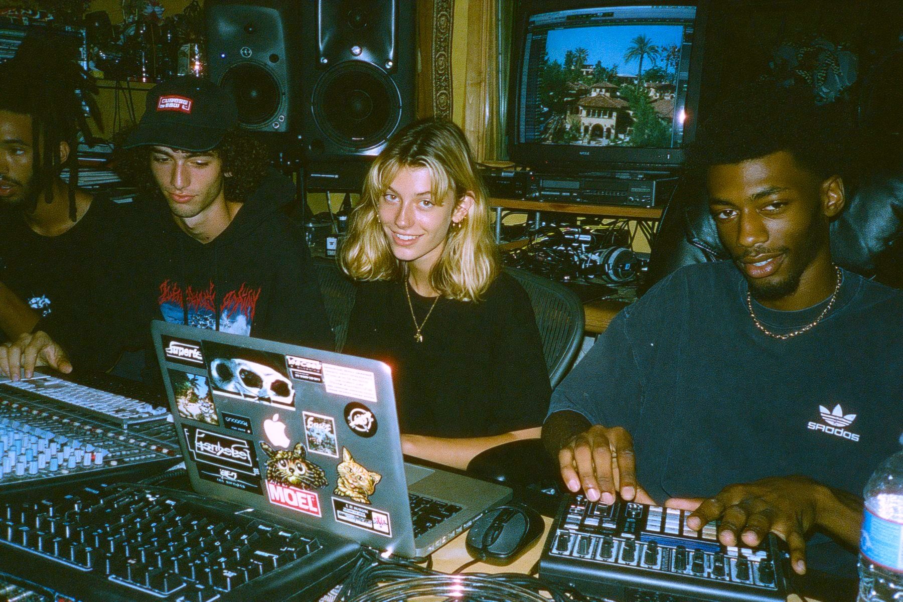 Three MPC members at a mixing desk in the studio, one on a laptop